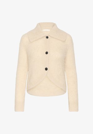 Krämmfärgad, fluffig cardigan med stor krage, tre svarta knappar framtill och rundad nederkant.