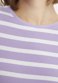 Lila randig t-shirt med vita horisontella ränder. Mjuk tyg, rund halsringning och jämn textur.