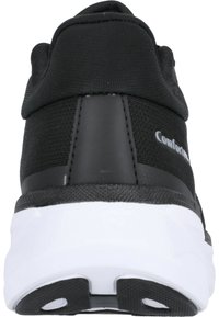 Baskets noires de sport avec un dessus en tissu texturé, des accents de talon en synthétique lisse, et une semelle en caoutchouc blanc avec un motif de semelle circulaire.