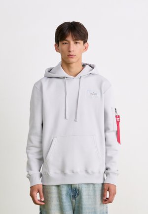 Lys grå hætte sweatshirt med en frontlomme, ribbede manchetter og en lynlåslomme på ærmet med et rødt stofmærke.