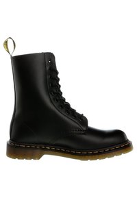 Bottines en cuir noir à lacets avec surpiqûres jaunes et semelle marron translucide, dotées d'une languette de traction marquée à l'arrière.