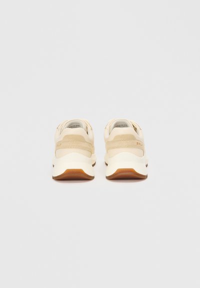 Beige Sneaker mit einem glatten Lederoberteil, gepolstertem Sohlen und kontrastierender Gummi-Außensohle. Merkmale ein minimalistisches Design ohne auffällige Akzente.
