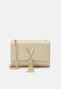 Borsa a pochette metallica dorata con tracolla a catena, caratterizzata da una spiccata chiusura a forma di V e un accento con frangia. Texture liscia senza motivi.