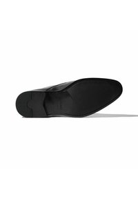 Suela de zapato de cuero negro con un acabado suave, forma redondeada y un patrón de agarre texturizado. Presenta una marca y un área del talón reforzada.