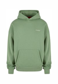 Haut à capuche en coton vert avec une poche kangourou, des poignets côtelés et un ourlet côtelé. Présente un petit logo blanc sur la poitrine. Tissu doux et texturé.