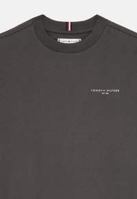 Mørkegrå sweatshirt med ribbet rund halsudskæring, prydet med et logo i hvidt og røde detaljer, lavet af blødt bomuldsstof.