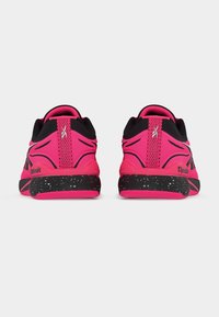 Ζευγάρι αθλητικών παπουτσιών Reebok σε έντονο ροζ και μαύρο χρώμα, που φαίνονται από πίσω με μαύρες σπογγώδεις μεσόσολες σε λευκό φόντο.