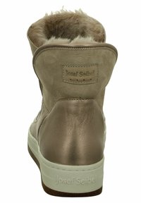 Braune Wildleder-Stiefeletten mit Kunstfellfutter, Lederakzenten und einer weißen Gummi-Sohle. Mit Logopatch auf der Rückseite.