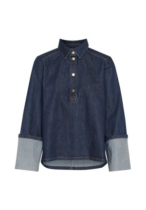 Denim top featuring a dark blue body, popover design, and metal buttons. Light blue contrasting cuffs and collar. Long sleeves, relaxed fit.