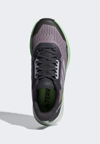 Scarpa sportiva grigia e verde con tomaia in rete, accenti neri e suola testurizzata. Caratterizzata da lacci, logo e collo imbottito.