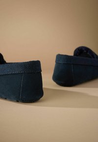 Papuci din suede albastru marin, cu un trim din țesătură herringbone, design cu spate jos și talpă texturată. Finisaj neted cu detalii discrete de cusătură.