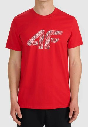 Mężczyzna w czerwonej koszulce z krótkim rękawem z białym, teksturowanym logo "4F" na środku klatki piersiowej.