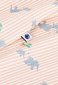 Βαμβακερό ύφασμα με ριγέ ροδάκινο και λευκό, διακοσμημένο με μπλε ελέφαντες και πράσινα καρότα. Περιλαμβάνει μικρή ετικέτα με το λογότυπο στη άκρη.