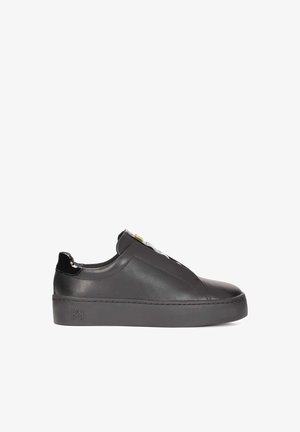 Baskets en cuir noir au design épuré, avec un embout arrondi, un devant élastiqué et une semelle extérieure texturée noire. Accents en doré.