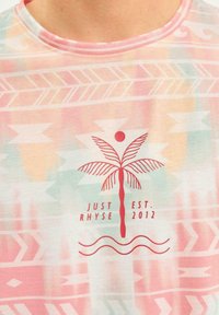 Short-sleeve t-shirt in pastel colors with an abstract pattern. Features a red palm tree graphic with sun, and text: "JUST EST. RHYSE 2012."