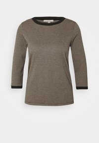 Chemise à manches longues à motif noir et beige avec un col rond et des bordures noires au niveau du col et des manches. Tissu texturé.