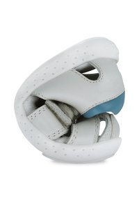 Zapato de cuero blanco con diseño perforado, forma curvada, acento azul en la puntera y correas ajustables para el cierre. Textura suave.