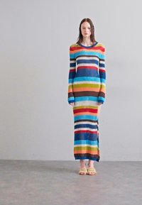 Langärmliges, geripptes Kleid mit kräftigen horizontalen Streifen in Rot, Blau, Grün und Orange. Knielang mit seitlichem Schlitz.