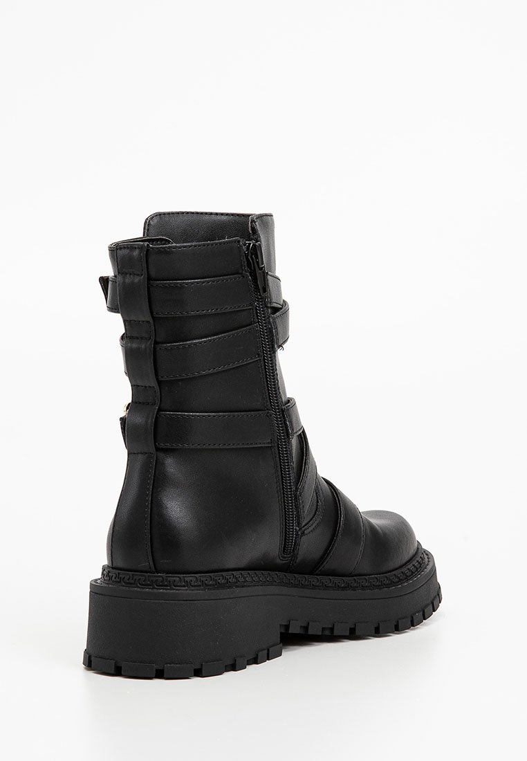Schwarze Leder Stiefelette mit runder Spitze, seitlichem Reißverschluss, dekorativen Riemen und einer robusten Gummisohle mit strukturierten Grip-Details.