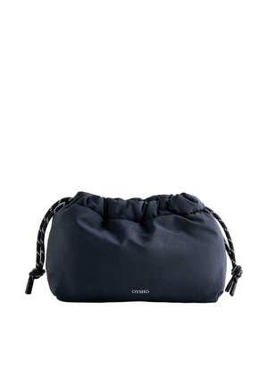 Mäkké čierne vrecko sťahovacieho typu s bielymi a čiernymi šnúrkami, malé logo „OYSHO“ umiestnené v strede blízko spodnej časti.