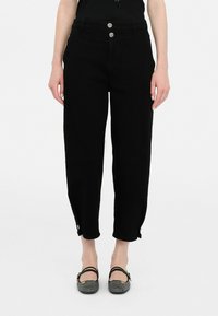 Jeans negri cu talie înaltă și croială lejeră, prevăzuți cu două nasturi în față, tivuri cu manșete și detalii cu nasturi, având o textură netedă din denim.