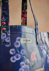 Marine totebag met bloemenpatroon, met roze en blauwe bloemen, een Cath Kidston-logo en duurzaam materiaal met contrasterende hengsels.