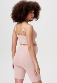 Lichtroze geribbelde crop top en bijpassende fietsshorts. Voorzien van verstelbare bandjes en een aansluitend ontwerp met een textuurstof.