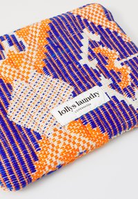 Szőtt tasak narancssárga, kék és fehér mintával, melyen a következő felirat áll: "lolly's laundry, COPENHAGEN." Texturált felület. Téglalap alakú.