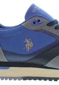 Blå och grå sneaker med läder- och mockamaterial. Har en gummisula, snörningsdesign och en guldlogo av en polo-spelare.