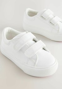 Vita sneakers i syntetläder med två kardborreband, rund tå, texturerade vita gummisulor och enkel design.