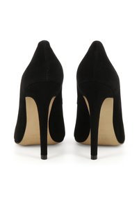 Chaussures à talons hauts en daim noir avec un bout pointu et un talon stiletto fin. Elles présentent une texture lisse et une semelle beige.