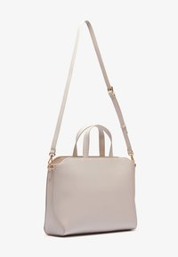 Beige leather handbag with two short handles and a long detachable shoulder strap. Smooth texture, gold-tone hardware, rectangular shape.