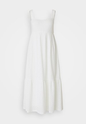 Robe en coton blanche avec bretelles ajustables, motif œillets, corsage cintré et ourlet à volants. Légère, fluide et de longueur genou.