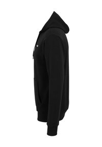 Hoodie nera con tasca frontale, cordino regolabile e polsini a coste. Realizzato in tessuto morbido e testurizzato, visibile in prospettiva laterale.