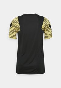 Svart sportströja med korta ärmar. Ärmarna har ett zigzag-mönster i gult. Tyget verkar lätt och slätt.