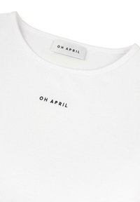 Bijela pamučna majica kratkih rukava s okruglim izrezom, na prednjoj strani sa malim crnim izvezenim logotipom "OH APRIL" u središtu. Mekani materijal.