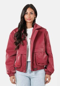 Rode bomberjack van nepleer met ritssluiting, oversized zakken en elastische manchetten, met een cropped ontwerp en een gladde textuur.