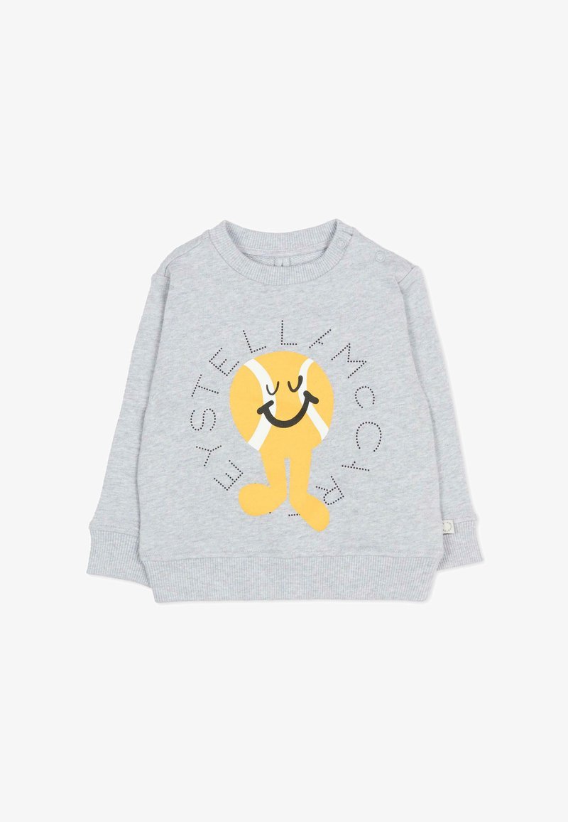 Sweat-shirt gris clair pour enfants avec un personnage de balle de tennis jaune souriante et le texte "Stella McCartney" autour.