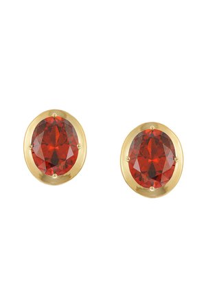 Gold stud earrings each featuring a large oval red gemstone with faceted cut held by four prongs on a white background.