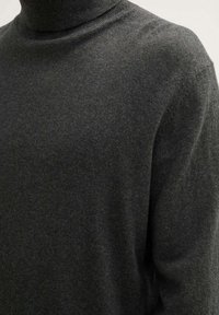 Ciemnoszary sweter typu golf wykonanego z miękkiej tkaniny, o dopasowanym kroju i prążkowanych wykończeniach przy kołnierzu i mankietach.