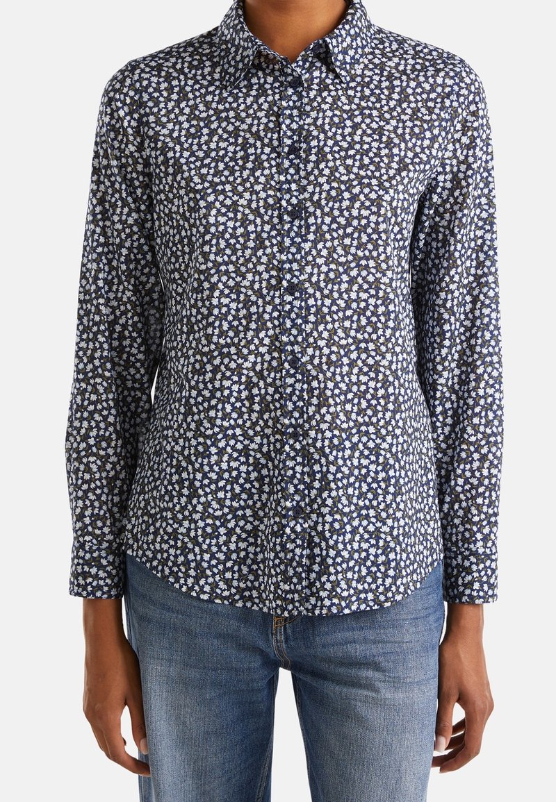 Marinblå skjorta med knappar, med ett vitt och gult blommönster, långa ärmar, krage och rak passform. Tillverkad av mjukt tyg.