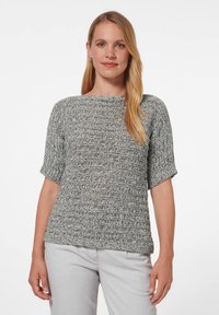 Grijze gebreide trui met een textuurpatroon, korte mouwen en een ronde halslijn. Gedragen met lichtgrijze broek, aansluitende pasvorm.