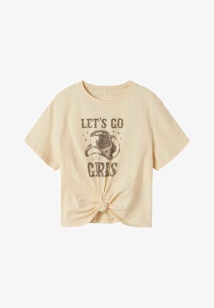 Licht beige cropped t-shirt met een geknoopt achtereind, voorzien van een grafische print van een cowboyhoed en de tekst "LET'S GO GIRLS" in bruin.