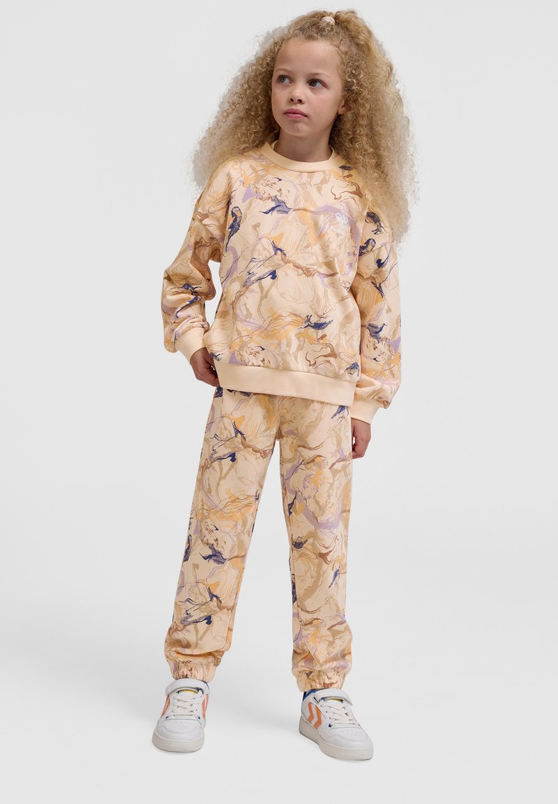 Sweatshirt en sweatpants set in licht perzik met abstracte gouden en paarse patronen, gemaakt van zachte stof. Beschikt over elastische boorden en een elastische tailleband.