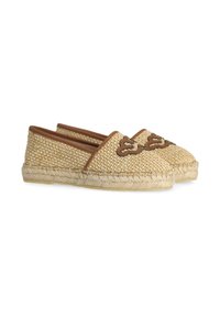 Espadrilles de paja tejida con acentos de cuero marrón, punta redonda y suela de yute trenzado, con costuras decorativas en marrón en la parte superior.