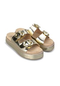 Sandali slide metallici oro con due larghe cinghie decorate da grandi fibbie circolari. Sottopiede morbido color tan e suola piatta spessa e strutturata.