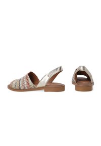 Textile Slingback-Sandalen mit einem gewobenen, mehrfarbigen Obermaterial, metallischen goldenen Akzenten und einer braunen flachen Sohle. Offenes Rückendesign für einfaches Anziehen.