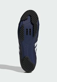 Pohja tummansinisille urheilukengille, jossa on teksturoitu musta kumipinta, kolme valkoista raitaa, ilmanvaihtoa varten leikattuja aukkoja ja sileä yläpinta.