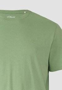 T-shirt en coton vert clair à manches courtes avec col rond et petit logo s.Oliver brodé sur le côté gauche de la poitrine.