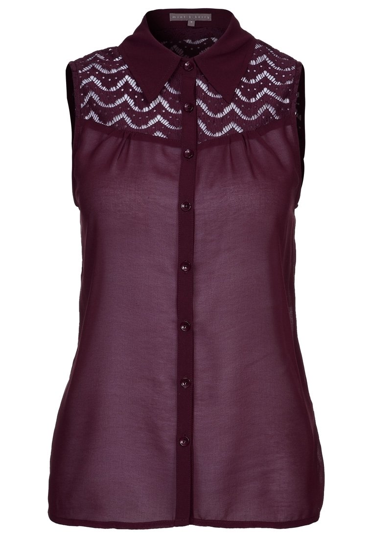 Burgundy ærmeløs bluse med en struktureret blondepanel, knaplukning foran og krave. Lavet af let, gennemsigtigt stof.
